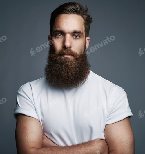 Preview: Bearded young man standing confidently with his arms crossed