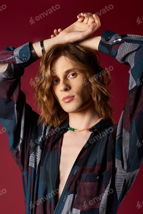 Preview: Elegant and confident young man showcases modern fashion in striking pose against vibrant backdrop