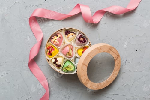 Preview: Holiday composition: sweet candy, with gift boxes with bow and chocolate hearts,