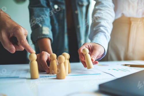 Preview: A group of business team brainstorming and planning strategy together withwooden people