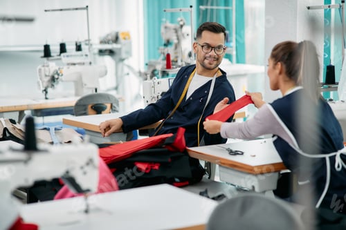 Preview: Young tail and his female coworker cooperating while sewing in a factory.