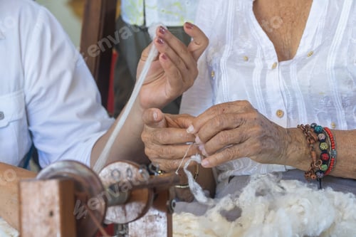 Preview: Close-up of hands skillfully extracting silk thread in a traditional artisanal manner