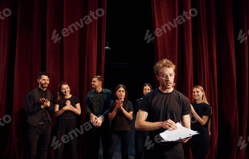 Preview: Group of actors in dark colored clothes on rehearsal in the theater