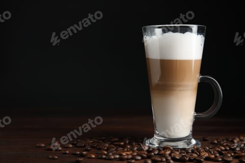 Preview: Delicious latte macchiato and coffee beans on wooden table, space for text