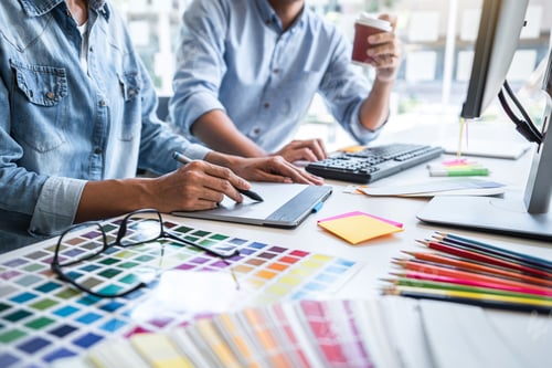 Preview: Young colleagues designers working together on a creative project and color samples for selection