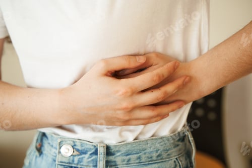 Preview: Stomach pain from pancreatitis. Young woman holds abdomen due to pancreas inflammation