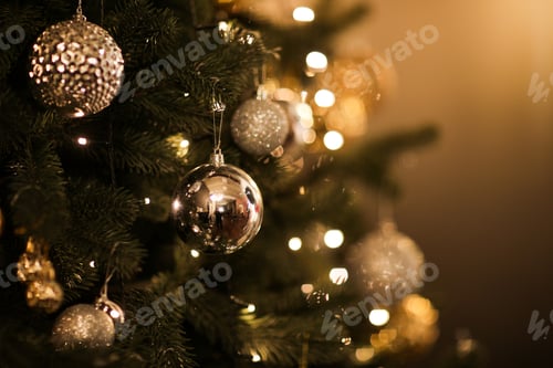 Preview: Close up view of beautiful fir branches with shiny golden bauble or ball, xmas ornaments and lights,