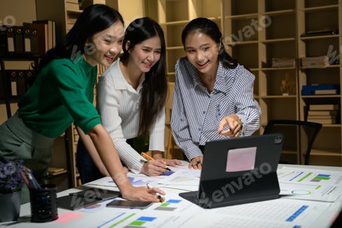 Preview: Young Businesswomen Collaborating on Project in Modern Office with Digital Tablet and Documents