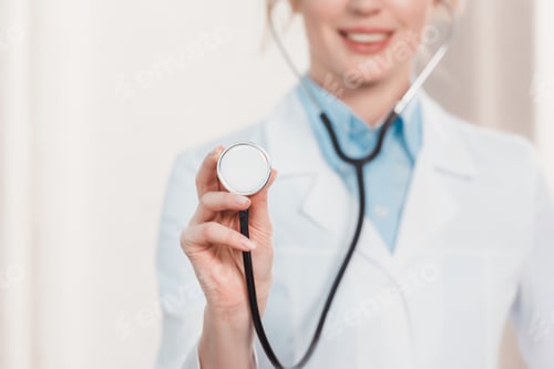 Preview: partial view of smiling doctor showing stethoscope in hand