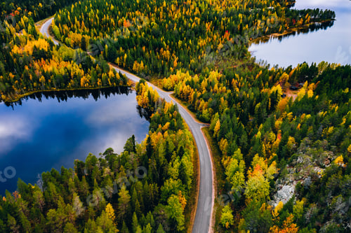 Preview: Aerial view of road and colorful autumn forest with mountains and blue lakes in Finland.