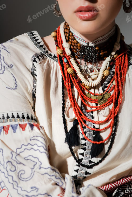 Preview: partial view of ukrainian woman in traditional clothes and floral red wreath isolated on grey