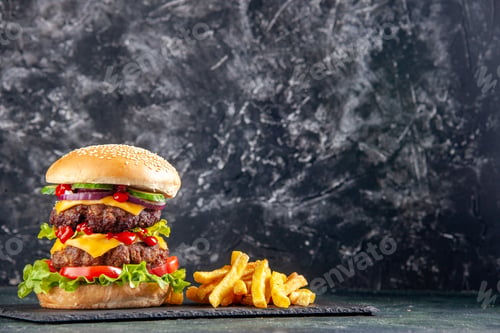 Preview: Delicious sandwich and fries on dark color tray on the right side on black background