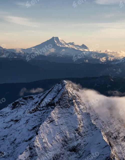 Preview: Aerial View of Canadian Rocky Mountains with snow on top during Fall Season Sunset