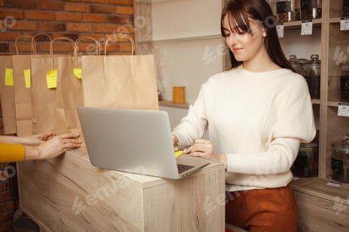 Preview: Online delivery in tea store. seller writes addresses of buyers for courier, home delivery. woman