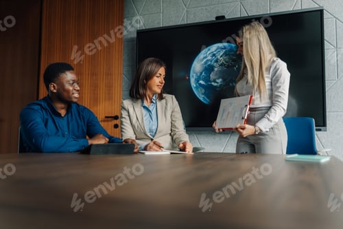 Preview: Diverse business team discussing global strategy in meeting room