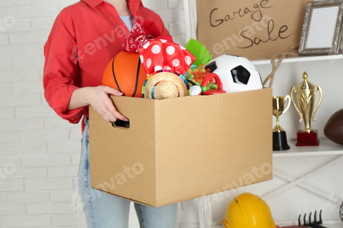 Preview: Woman holding box of unwanted stuff indoors, closeup