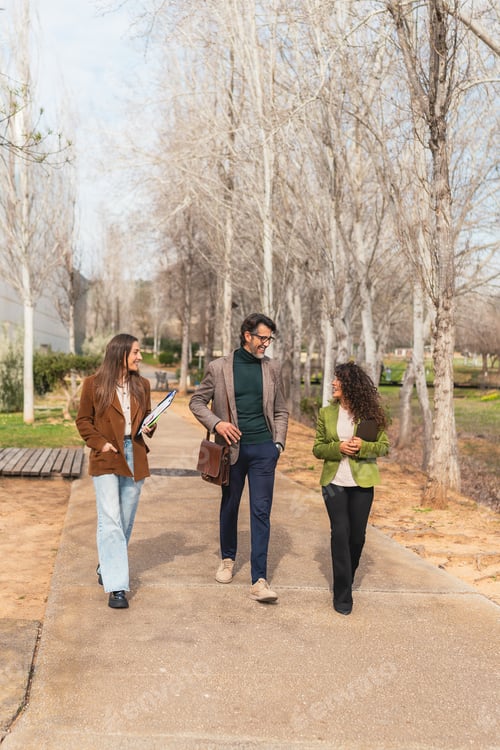 Preview: Business colleagues walking outdoors discussing work