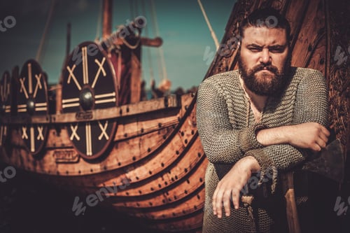 Preview: Viking with axe standing near drakkar on the seashore.