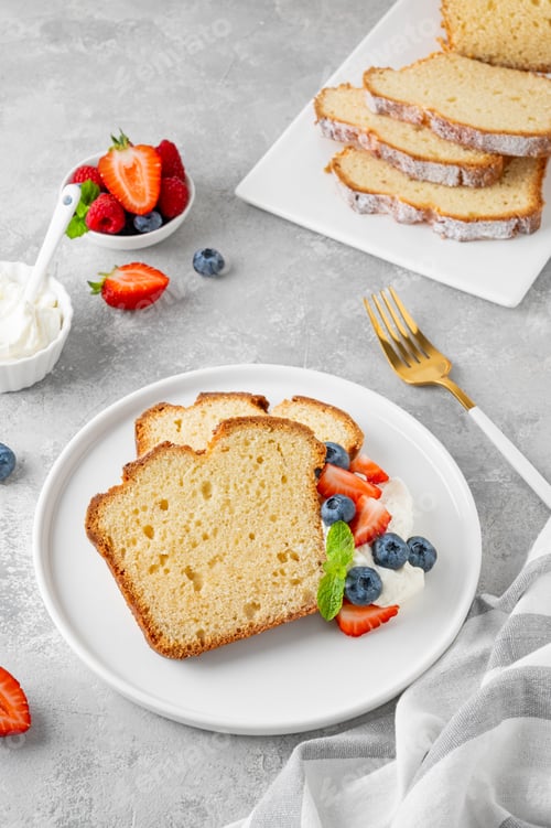 Preview: Vanilla pound cake served with fresh berries and whipped cream on a gray concrete background