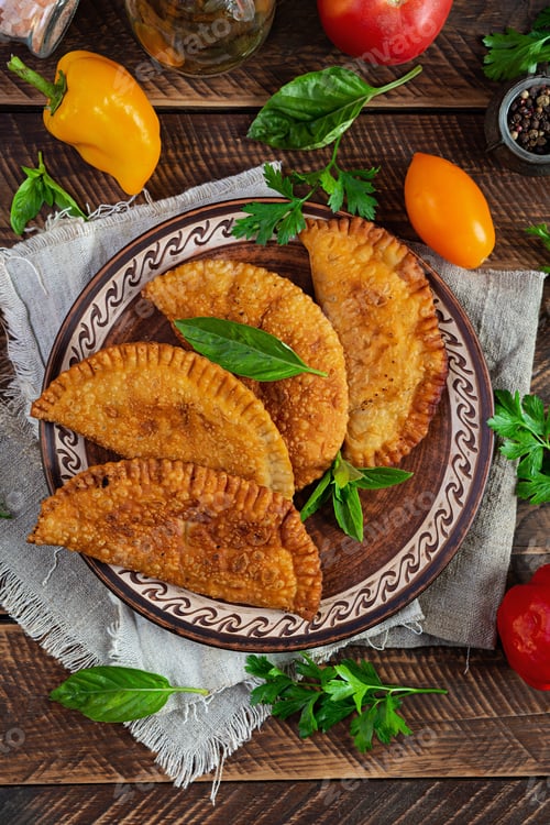 Preview: Traditional Crimean Tatar cuisine, chebureki with chicken meat. Fried empanadas on wooden background