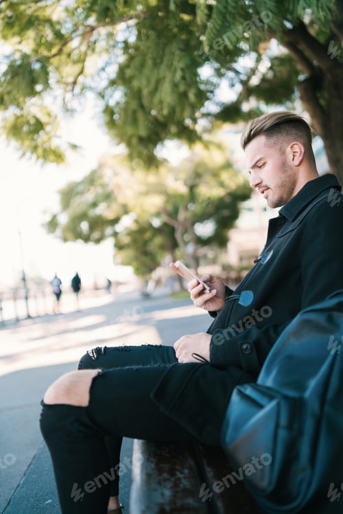 Preview: Man Relaxing Outdoors with his Smartphone
