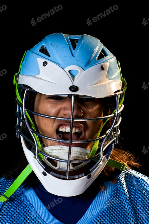 Preview: Young male lacrosse player in lacrosse helmet shouting, close up portrait against black background