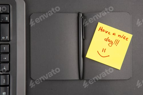 Preview: top view black notebook pen keyboard have a nice day written on note paper on dark background
