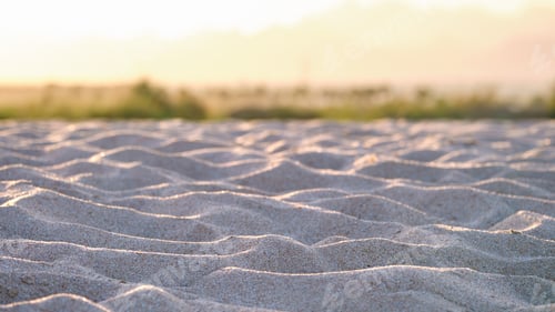 Preview: Close up of clean yellow sand surface covering seaside beach illuminated with evening light. Travel