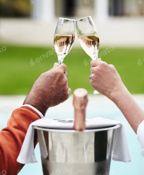 Preview: Closeup of a senior couple clinking their champagne glasses together while on vacation
