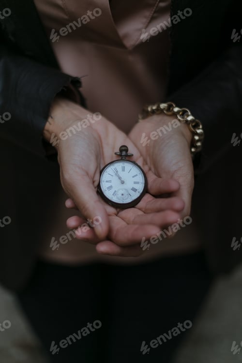 Preview: Vertical shot of an unrecognizable woman holding an antique watch