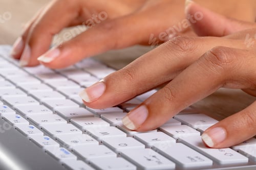 Preview: Close up of businesswoman typing on keyboard on wooden table against grey background