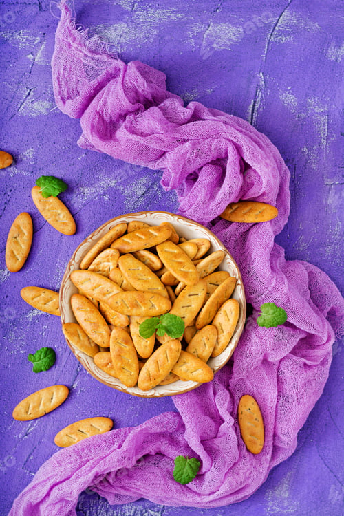 Preview: Cookies in a bowl on a purple background. Flat lay. Top view