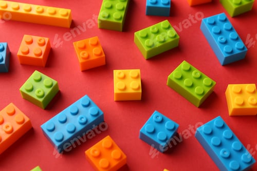 Preview: Construction toy. Colorful building bricks on red background, closeup