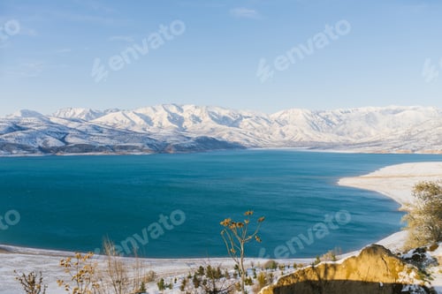 Preview: Charvak Reservoir in Uzbekistan in Winter with Blue Water in it, Surrounded by Tien Shan Mountain