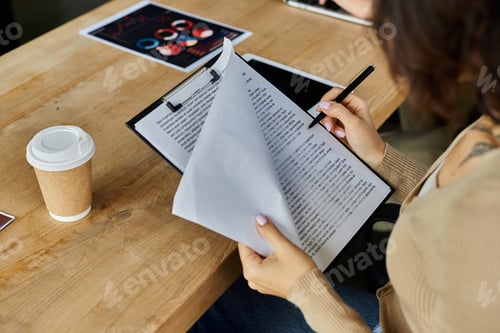 Preview: Focused professional reviews important documents in a bustling office environment