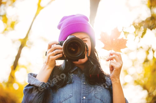 Preview: girl in hat with professional camera on fall season park