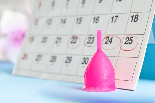 Preview: Calendar page and menstrual cup close up