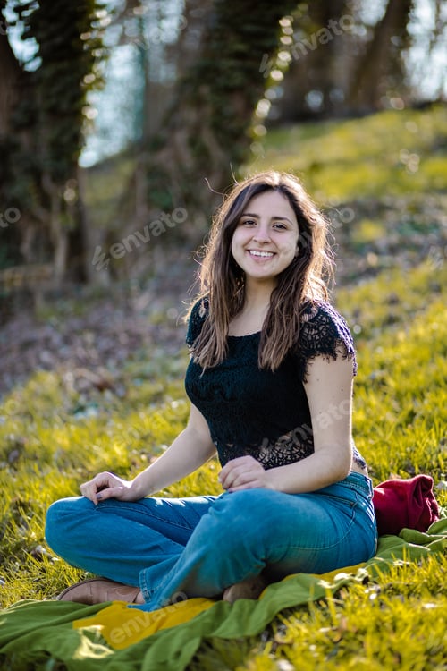 Preview: Young brunette sitting in the park