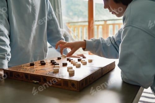 Preview: Brothers playing checkers at home, siblings playing the board strategy game, spending time together