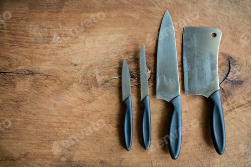 Preview: Set of kitchen knifes on wooden cutting board on old wooden table
