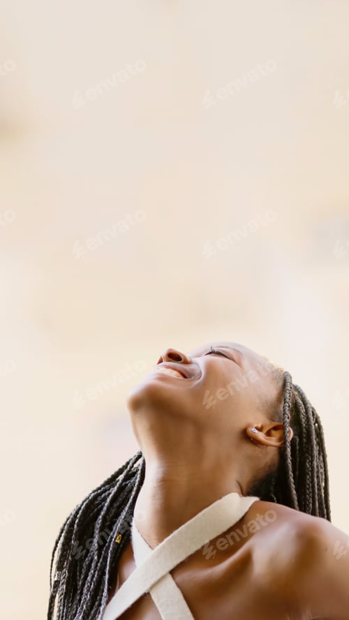 Preview: Young black woman looking up smiling