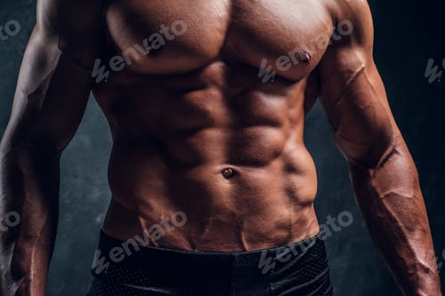 Preview: Close-up image of muscular torso with dark wall background