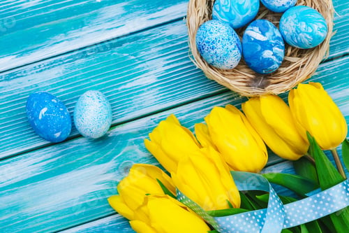 Preview: Easter eggs and tulips. Festive decoration on wood background. Holiday card with copy space