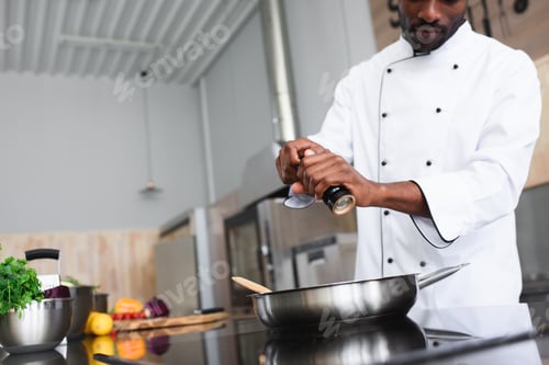 Preview: African american chef seasoning dish by kitchen stove