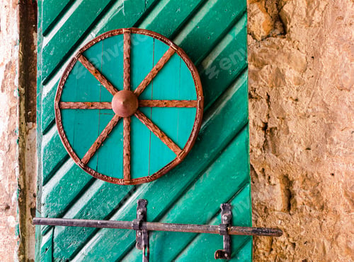 Preview: Wooden wheel attached to a green door