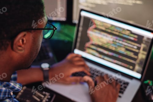 Preview: Black male in front of computer screen coding mobile app, web development, computer programming