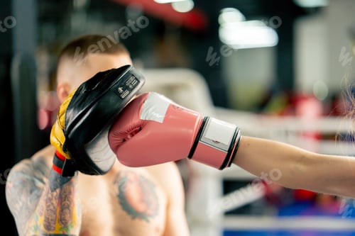 Preview: close u pin a boxing fight club a young girl in a black sweatshirt with pink gloves practices with a