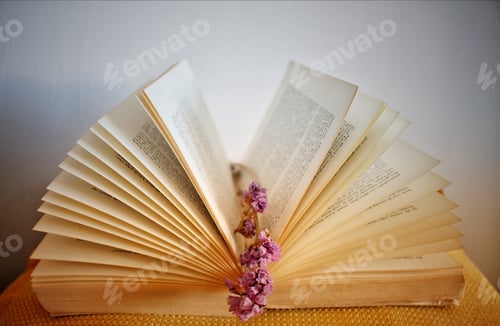Preview: Closeup of dried flowers in between book sheets on the table