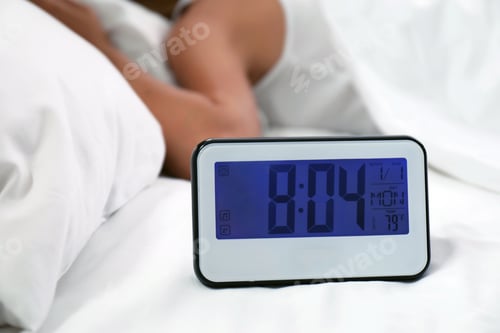 Preview: Digital alarm clock and sleepy woman in bed. Time of day