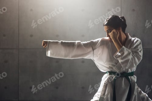 Preview: Woman Practicing a Punching Pose in White Gi